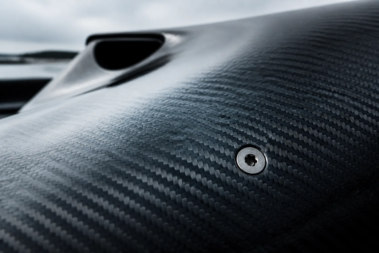 Bare carbon fibre weave over a compound curve
